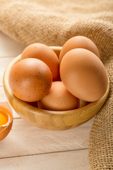 Bowl with egs on white wooden background