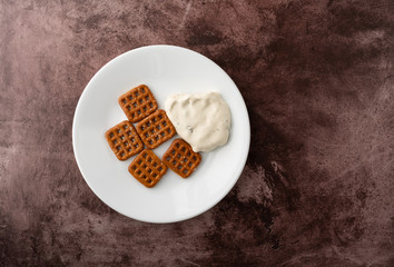 Waffle pretzels with cream cheese on a plate top view