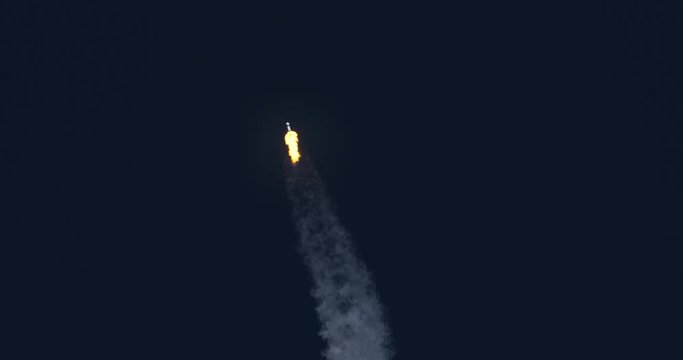 Space rocket or ICBM missile soars into space with bright trail of white smoke and exhaust in a clear blue sky.  4K at 120 fps slow motion. With audio.