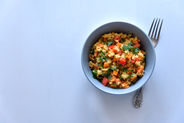 Healhty vegan bowl with quinoa, pumpkin, pepper and carrot on gray wooden background. Selective focus