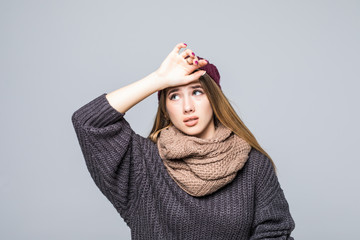 Portrait of a sad woman dressed sweater and scarf look on themperature isolated over white background