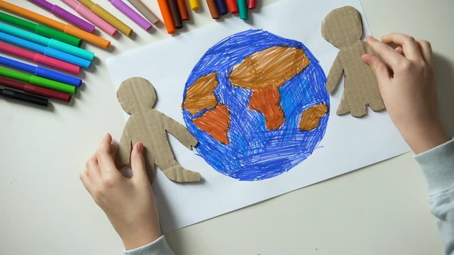 Kid putting paper family on Earth painting, environmental saving concept