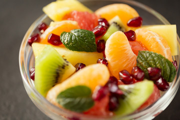Bowl of healthy fresh fruit salad on black background.