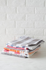 Stack of kitchen towels or napkins in interior of white kitchen.