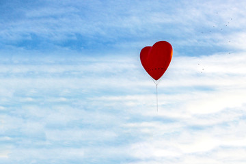 Naklejka na ściany i meble Balloon in the shape of heart is flying among the clouds, copy space for Valentine's Day, Mother's Day or Women's Day.