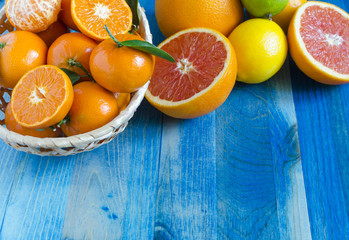 Tangerines lemons oranges lime citrus close-up on blue background copy space