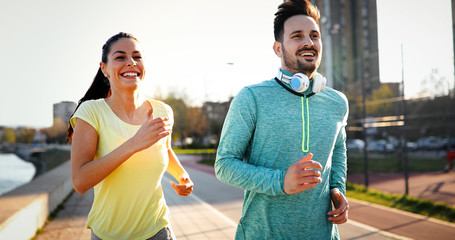 Young fitness couple running in urban area