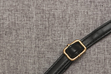 strip of black leather with straps for adjusting