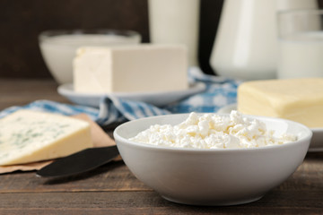 milk products. milk, sour cream, cheese, butter and cottage cheese on a brown wooden table