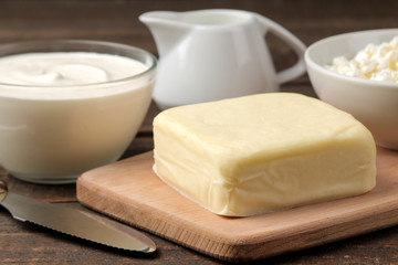 milk products. milk, sour cream, cheese, butter and cottage cheese on a brown wooden table