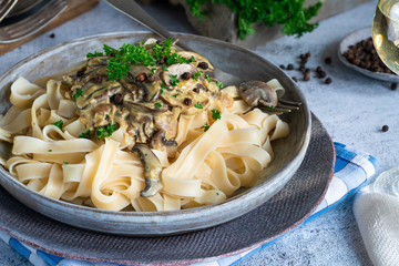 Pasta tagliatelle and mushrooms in creamy sauce with brandy and peppercorns