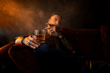 Portrait of an attractive business man with a cigar and a glass of whiskey