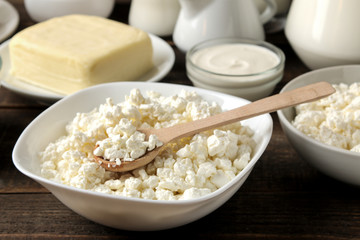 milk products. cottage cheese closeup, milk, sour cream, cheese, butter on a brown wooden table.