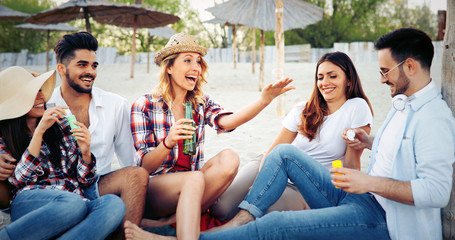 Friends partying and having fun on beach at summer