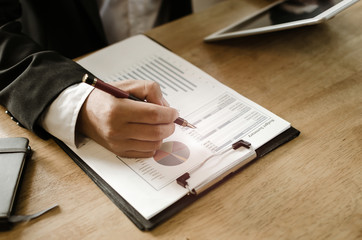 professional investor or business man analysis and calculating on financial reports and using...
