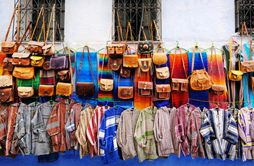 Moroccan handmade crafts, carpets and bags hanging in the narrow street of Essaouira in Morocco...