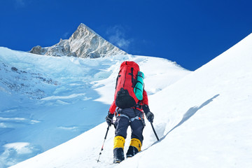 Climber reaches the summit of mountain peak. Success, freedom and happiness, achievement in mountains. Climbing sport concept.