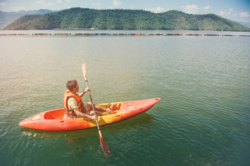 man kayaking in dam river with mountain landscape view