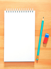 Blank notepad and pencil on the wooden table