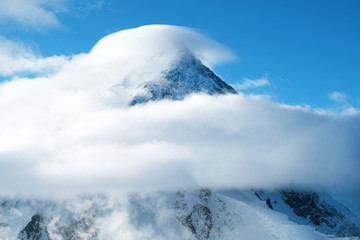 Snowy mountain peak inside clouds in Himalaya