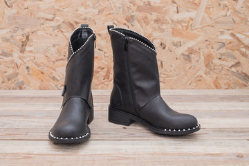 Winter boot with fur lining at wood background, close-up