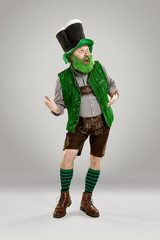 A smiling happy senior man in a leprechaun hat with beard at studio. He celebrates St. Patrick's...