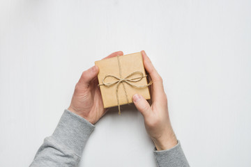 man's hands holds a gift in a box on a white background