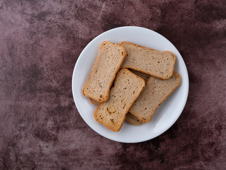 Rye melba toast slices on a white dish