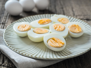 Boiled chicken eggs on a gray plate. Wooden background. The concept of Easter