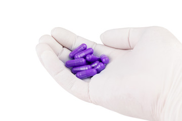 hand in medical glove holding proton purple color organic med capsules isolated on white background...