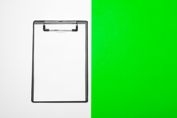 Blank clipboard paper on bright green paper background, copy space