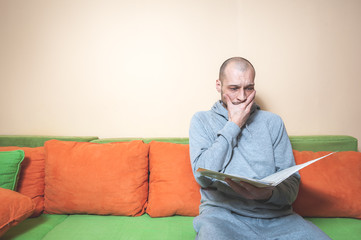 Young or middle age sick man in the casual clothes reading medical results on the papers from his doctor and realize that he have diagnosed a cancer or other sickness 