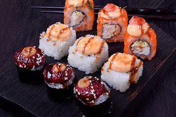 Sushi rolls assortment on a black board