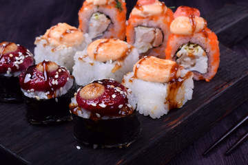 Sushi rolls assortment on a black board