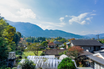 Fototapeta premium The View of Yufuin countryside with Mount Yufu in Background and blue sky with clouds in autumn season. onsen town, Yufuin, Oita, Kyushu, Japan