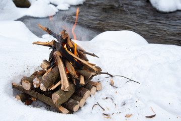 Campfire on snow in the winter forest