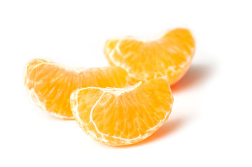 pieces of peeled tangerine on white background