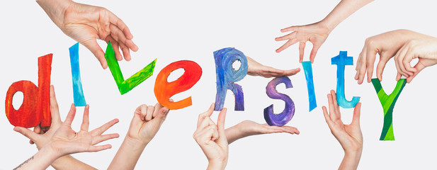 DIVERSITY inscription put up with colorful letters held by the hands on a white background