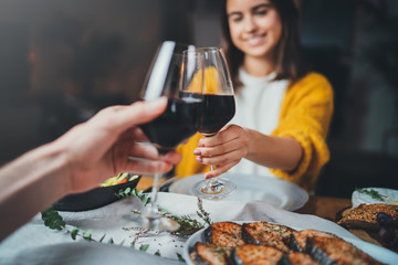 Romantic couple enjoying dinner at home, concept love, relationship and romantic, happy couple celebrating and making cheers with glasses of red wine