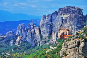 Fototapeta na wymiar Monastery Meteora Greece. Stunning summer panoramic landscape. mountains and green forest against epic blue sky with clouds UNESCO heritage list object. Aerial view Great Meteor and Rousanou Monastery