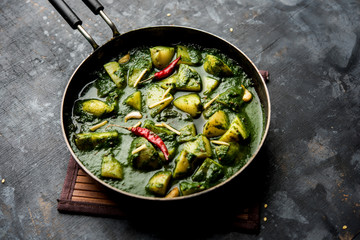 Aloo Palak sabzi or Spinach Potatoes curry served in a bowl. Popular Indian healthy recipe. Selective focus
