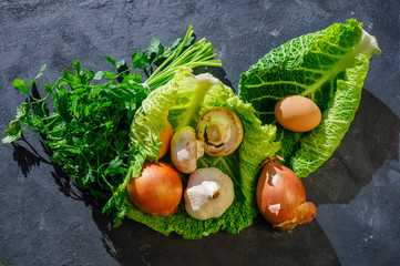 vegetables and eggs for cooking on rustic black background