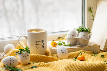 Happy Easter card. Cute Easter eggs with a painted face in a spring wreath, cup tea with kumquat. Happy easter