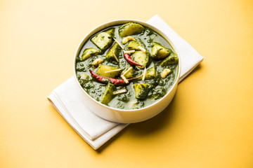 Aloo Palak sabzi or Spinach Potatoes curry served in a bowl. Popular Indian healthy recipe. Selective focus