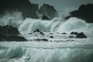 Waves crash along the black lava rock cliffs. Lanzarote, Canary Islands.