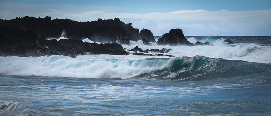 Waves crash along the black lava rock cliffs. Lanzarote, Canary Islands.