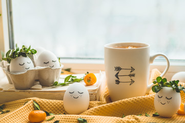 Happy Easter card. Cute Easter eggs with a painted face in a spring wreath, cup tea with kumquat. Happy easter