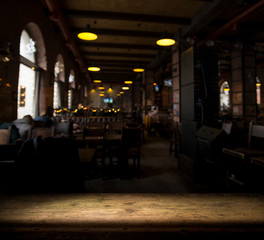 image of wooden table in front of abstract blurred background of resturant lights