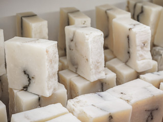 Bars of soap on a shop window. Pure natural soap with cedar oil and herbal ingredients. Handmade natural cold process soap. Eco-friendly exfoliating soap for hair and body