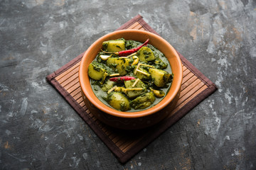 Aloo Palak sabzi or Spinach Potatoes curry served in a bowl. Popular Indian healthy recipe. Selective focus